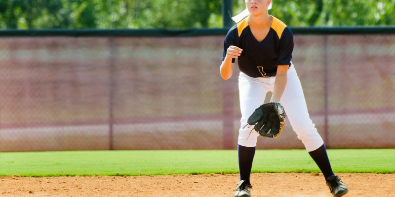 Teen girl playing softball in organized game